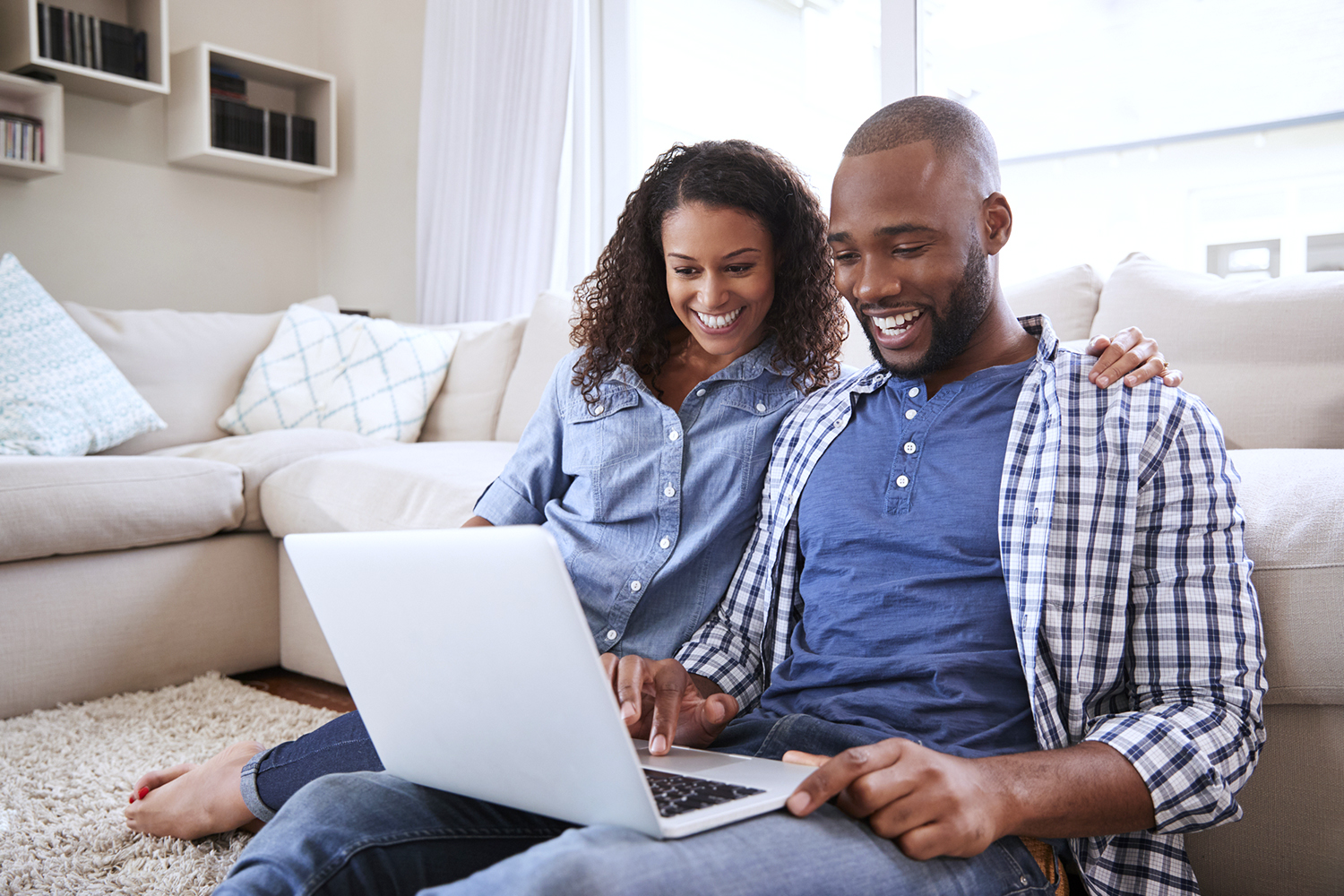 Young couple on the floor of their new house looking at their online home inspections report